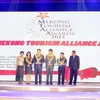 Ông Lê Thanh Lợi, Giám đốc Trung tâm Du lịch Phong Nha-Kẻ Bàng (thứ năm từ trái sang) nhận giải “"Di sản hữu hình xuất sắc nhất năm 2015" cho Phong Nha-Kẻ Bàng. (Ảnh: Hi Trang/Vietnam+) 