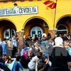 Một nhóm người di cư đợi cảnh sát Macedonia cho phép lên tàu hỏa tại nhà ga ở Gevgelija, Macedonia ngày 21/8. (Ảnh: AFP/TTXVN)