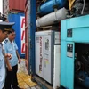 Lực lượng chức năng mở kiểm tra các container hàng nhập lậu tại khu vực Cảng Hiệp Phước. (Ảnh: Mạnh Linh/TTXVN) 