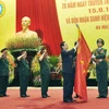 Thủ tướng Nguyễn Tấn Dũng gắn Huy hiệu Anh hùng lực lượng vũ trang nhân dân lên Cờ truyền thống của Tổng cục Công nghiệp Quốc phòng. (Ảnh: Trọng Đức/TTXVN) 