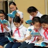 Học sinh trường Nguyễn Đình Chiểu (Hà Nội) với cuốn sách Quyền trẻ em. (Ảnh: Nguyễn Thủy/TTXVN)