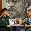 Thiếu tướng Phạm Văn Huấn trao tặng bức ảnh lịch sử về chuyến thăm Việt Nam của Chủ tịch Fidel Castro cho Phó Chủ tịch thứ nhất Upec Aixa Hevia. (Ảnh: Lê Hà/TTXVN) 