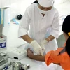 Cán bộ y tế của Trung tâm phòng chống HIV/AIDS tỉnh Ninh Bình lấy mẫu máu xét nghiệm HIV/AIDS. (Ảnh: Dương Ngọc/TTXVN) 