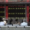 Nhà đầu tư theo dõi bảng tỷ giá chứng khoán tại thủ đô Bắc Kinh, Trung Quốc. (Nguồn: AFP/TTXVN)