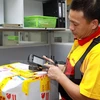 Nhân viên DHL dùng máy quét mã vạch không dây để quản lý hàng hóa. (Ảnh: Minh Tú/TTXVN)