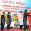 Chủ tịch nước Trương Tấn Sang gắn Huân chương Sao Vàng lên là cờ truyền thống của ngành ngoại giao Việt Nam. (Ảnh: Thống Nhất/TTXVN)