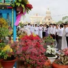 Các đại biểu tham quan gian triển lãm hoa kiểng của Hội thánh Cao Đài Tây Ninh. (Ảnh: Lê Đức Hoảnh/TTXVN)