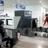 Nhân viên hải quan kiểm tra hành lý khách nhập cảnh qua hệ thống máy soi tại sân bay Tân Sơn Nhất. (Ảnh: Hoàng Hùng/TTXVN)