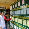 Cử tri huyện Hương Trà, tỉnh Thừa Thiên-Huế tìm hiểu các ứng cử viên tại một điểm niêm yết công khai. (Ảnh: Hồ Cầu/TTXVN) 