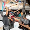 Lực lượng cứu hộ giải cứu người còn sống bị mắc kẹt trong một căn nhà đổ nát sau trận động đất. (Ảnh: AFP/TTXVN)