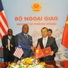 Thứ trưởng Ngoại giao Vũ Hồng Nam và Đại sứ Liberia tại Trung Quốc D.McKinley Thomas ký thông cáo thiết lập quan hệ ngoại giao Việt Nam-Liberia. (Ảnh: Nguyễn Khang/TTXVN)