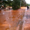 Sự cố vỡ bờ moong tại mỏ titan Suối Nhum khiến đất đỏ và bùn chảy tràn qua đường. (Ảnh: Nguyễn Thanh/TTXVN) 