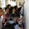Phụ huynh và học sinh xem kết quả kỳ thi tuyển sinh lớp 10 tại trường THPT Chuyên Lê Hồng Phong. (Ảnh: Phương Vy/TTXVN)