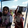 Trẻ em Iraq xếp hàng nhận lương thực cứu trợ tại khu vực Dora, ngoại ô thủ đô Baghdad ngày 31/5. (Nguồn: AFP/TTXVN)