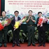 Thượng tướng Lương Cường tặng hoa chúc mừng các đơn vị tại lễ ký. (Ảnh: An Đăng/TTXVN) 