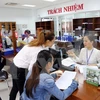 Hướng dẫn người dân giải quyết thủ tục hành chính tại khu vực giao dịch một cửa điện tử ở Trung tâm hành chính Đà Nẵng. (Ảnh: Trần Lê Lâm/TTXVN)