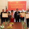 Đại sứ Đoàn Xuân Hưng trao Huân trương cho một số tổ chức và bạn bè Đức. (Ảnh: Mạnh Hùng/Vietnam+) 