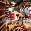 Du khách nước ngoài tham quan cơ sở sản xuất nước mắm đặc sản tại thị xã An Thới, huyện Phú Quốc. (Ảnh: Đình Huệ/TTXVN)
