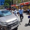 Lực lượng chức năng quận 1 xử lý xe ôtô đậu lấn chiếm lề đường Nguyễn Thái Bình. (Ảnh: Mạnh Linh/TTXVN)