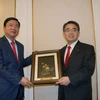 Bí thư Thành ủy Thành phố Hồ Chí Minh Đinh La Thăng tặng quà Thống đốc tỉnh Aichi Hideaki Ohmura. (Ảnh: Tiến Lực/Vietnam+)