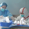 Nhân viên y tế Trung Quốc điều trị cho một bệnh nhân nhiễm virus cúm gia cầm H7N9. (Nguồn: EPA/TTXVN)