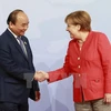 Thủ tướng Đức Angela Merkel đón Thủ tướng Nguyễn Xuân Phúc. (Ảnh: Thống Nhất/TTXVN)