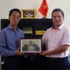 Đại diện TTXVN trao tặng ảnh về quan hệ Việt Nam-Algeria cho Đại sứ Phạm Quốc Trụ. (Ảnh: Quang Trường/Vietnam+)