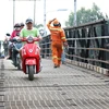 Người dân đôi bờ sông Phước Kiểng lưu thông qua lại cầu Long Kiểng. (Ảnh: Trần Xuân Tình/TTXVN)