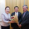 Đại sứ Phạm Quang Vinh (phải) tặng hoa chúc mừng Đại sứ Mai Sayavongs và phu nhân. (Ảnh: Đoan Hùng/Vietnam+)
