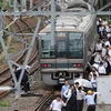 Hành khách sơ tán khỏi tàu hỏa sau trận động đất tại Osaka, Nhật Bản ngày 18/6. (Nguồn: AFP/TTXVN)