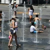 Trẻ em chơi đùa bên vòi phun nước để tránh nắng nóng tại Montreal, Canada ngày 3/7. (Ảnh: AFP/ TTXVN)