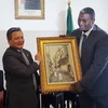Bộ trưởng Du lịch và Nghề thủ công Algeria Abdelkader Benmessaoud trao bức tranh lưu niệm tặng Đại sứ Việt Nam tại Algeria Phạm Quốc Trụ . (Ảnh: Tấn Đạt/TTXVN)