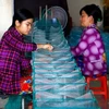 Người dân làng lưới Thơm Rơm tất bật sản xuất hàng phục vụ nhu cầu đánh bắt thủy sản trong mùa lũ. (Ảnh: Thanh Liêm/TTXVN)