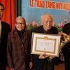 Trao tặng Huy hiệu 70 năm tuổi Đảng cho đảng viên lão thành Lê Xuân Bá. (Ảnh: Hồng Kỳ/Vietnam+)