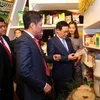 Phó Thủ tướng Vương Đình Huệ, Bộ trưởng Bộ Công thương Trần Tuấn Anh tham quan các gian hàng trưng bày sản phẩm gạo. (Ảnh: Danh Lam/TTXVN)