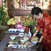 Nghệ nhân Ánh Tuyết với mâm cỗ Tết truyền thống Hà Nội. (Ảnh: Đinh Thị Thuận/TTXVN)