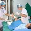 Các y bác sỹ Bệnh viện Đa khoa Hùng Vương điều trị vết thương cho bệnh nhi bị bỏng. (Ảnh: Trung Kiên/TTXVN)