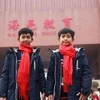 Thuch Salik (trái) đứng trước Trường Ngoại ngữ Hailiang ở tỉnh Chiết Giang, Trung Quốc. (Nguồn: Facebook/Thuch Salik)
