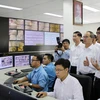 Bí thư Thành ủy Thành phố Hồ Chí Minh Nguyễn Thiện Nhân nghe báo cáo về hệ thống camera giám sát giao thông của Trung tâm điều hành giao thông thông minh. (Ảnh: Tiến Lực/TTXVN)
