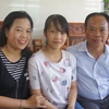 Em Hà Phương và bố mẹ trong niềm vui đón nhận danh hiệu thủ khoa toàn quốc. (Nguồn: TTXVN)