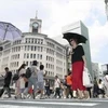 Người dân che ô tránh nắng tại Ginza, thủ đô Tokyo, Nhật Bản ngày 14/7. (Ảnh: Kyodo/TTXVN)