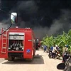 Xe chuyên dụng cùng lực lượng phòng cháy chữa cháy tiếp cận hiện trường tham gia dập lửa. (Ảnh: Sỹ Tuyên/TTXVN)