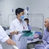 Bác sỹ Bệnh viện Đa khoa hữu nghị 103 tư vấn, theo dõi tình hình sức khỏe cho bệnh nhân. (Ảnh: Đức Tưởng/TTXVN)