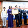 Phó Chủ tịch nước Đặng Thị Ngọc Thịnh trao tặng Huân chương Lao động hạng Nhất cho lãnh đạo bệnh viện Đại học Y dược Thành phố Hồ Chí Minh. (Ảnh: Đinh Hằng/TTXVN)