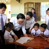 Bộ trưởng Phùng Xuân Nhạ với thầy trò Trường tiểu học Tân Hóa, huyện Minh Hóa, tỉnh Quảng Bình. (Ảnh: Văn Tý/TTXVN)