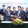 Ông Nguyễn Hồng Minh, Tổng cục trưởng Tổng cục Giáo dục nghề nghiệp và ông Mu Jang Byun, Phó chủ tịch Cơ quan Phát triển nguồn nhân lực Hàn Quốc (HRD) trao bản ký kết thoả thuận hợp tác. (Ảnh: Minh Quyết/TTXVN)