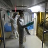 Nhân viên phun thuốc khử trùng tại tàu điện ngầm nhằm ngăn chặn sự lây lan của COVID-19 tại Tehran, Iran, ngày 26/2/2020. (Ảnh: AFP/TTXVN)