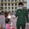Kiểm tra thân nhiệt công dân tại Trung tâm Giáo dục quốc phòng Trường Quân sự Bộ Tư lệnh Thủ đô Hà Nội. (Ảnh: Nguyễn Cúc/TTXVN) 