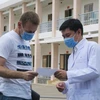 Bác sỹ Trần Chánh Xuân, Phó Giám đốc Bệnh viện Dã chiến Củ Chi trao chứng nhận xuất viện cho bệnh nhân mắc COVID-19. (Ảnh: Đinh Hằng/TTXVN)