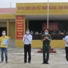 Đại diện trường Quân sự, Quân đoàn I, tỉnh Ninh Bình trao giấy chứng nhận hoàn thành thời gian cách ly cho công dân. (Ảnh: Hải Yến/TTXVN)